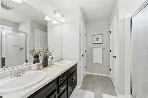 a en suite bathroom with a double vanity sink a mirror and a shower