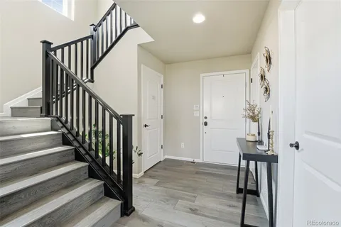 a view of a hallway with wooden floor and entryway