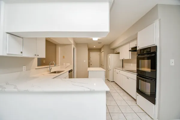 a large white kitchen with a stove a sink a washer and dryer