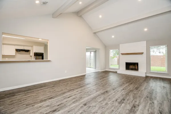 an empty room with wooden floor and fireplace