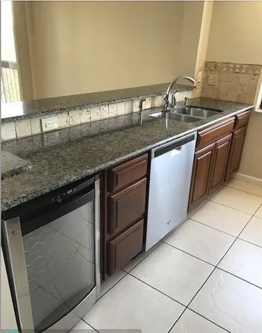 a kitchen with granite countertop a sink and a stove
