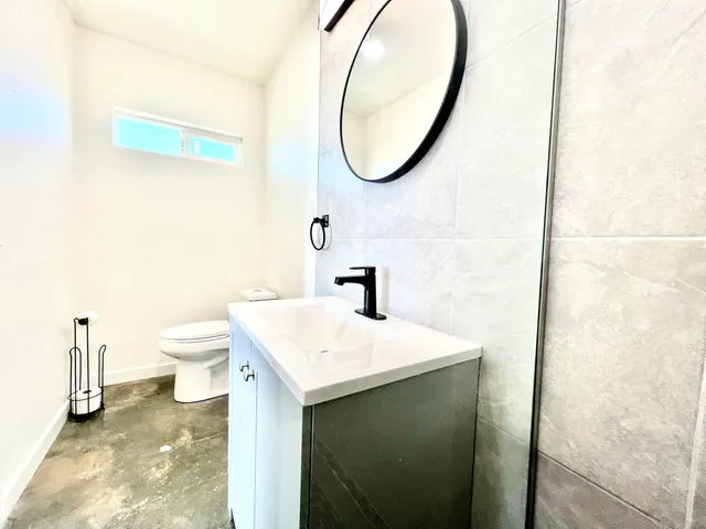a bathroom with a sink a toilet and a mirror