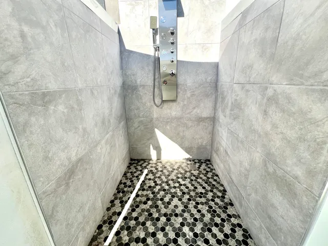 a bathroom with a sink a toilet a shower and a window