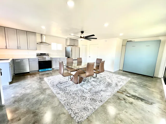 a living room with a couch and a kitchen with sink