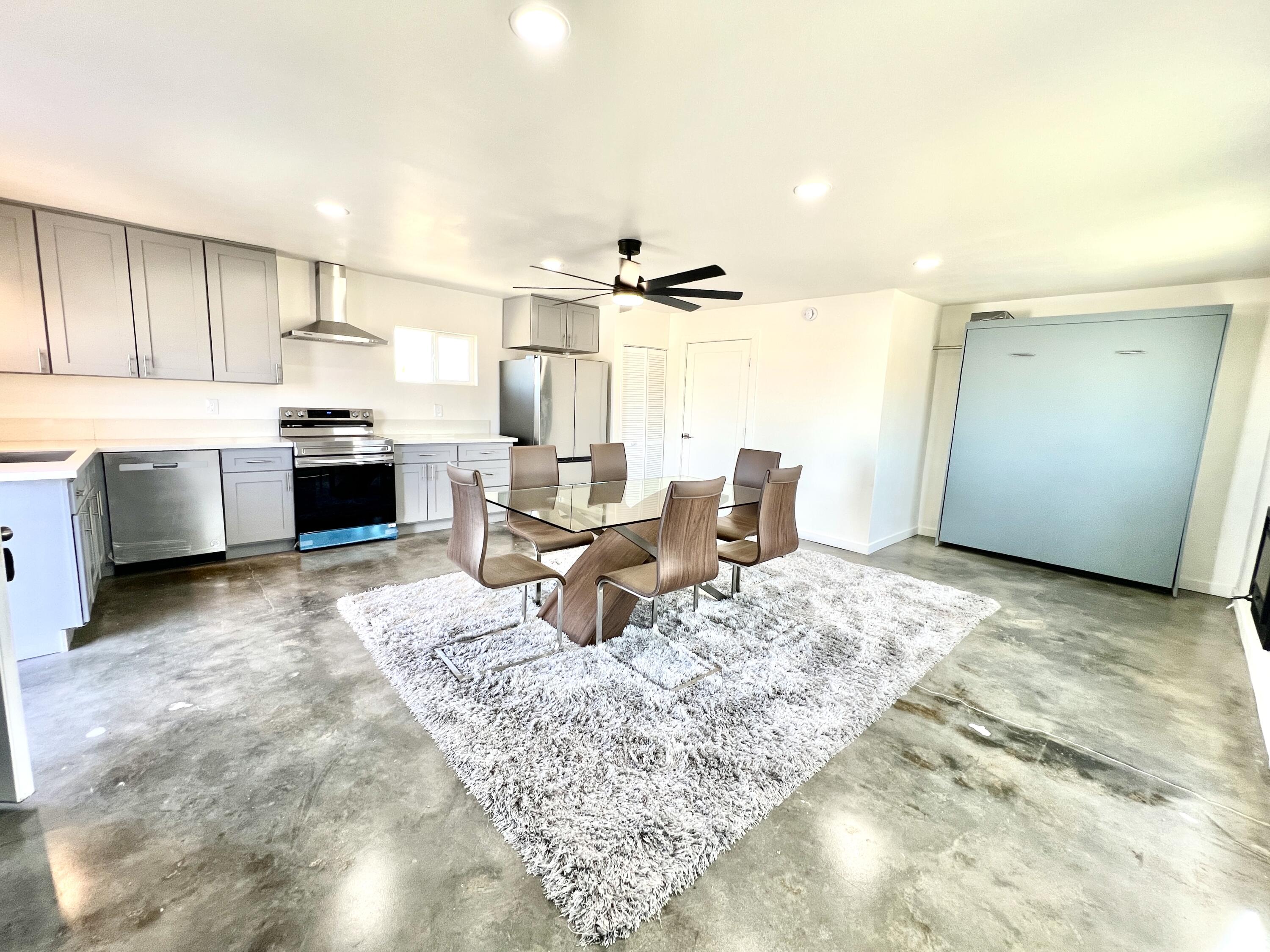 2774 Kickapoo Trail Landers, CA 92285 - Photo 3 of 51 a living room with a couch and a kitchen with sink