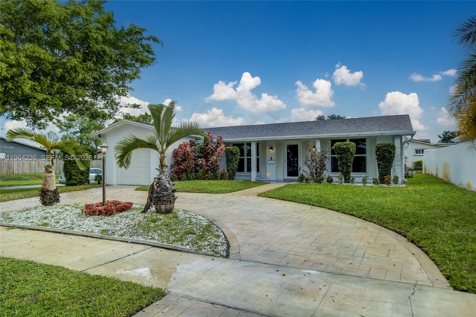 4917 West Park Road Hollywood, FL 33021 - Photo 3 of 25 a front view of a house with a yard and a garage
