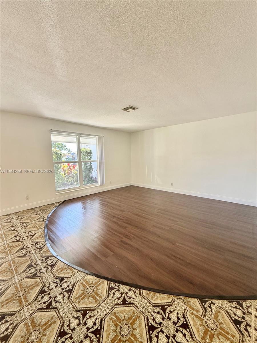 4917 West Park Road Hollywood, FL 33021 - Photo 7 of 25 an empty room with wooden floor and windows