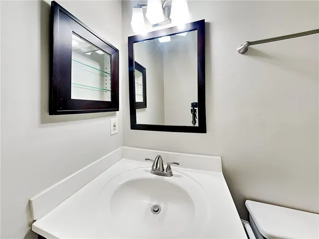 a bathroom with a toilet sink and mirror
