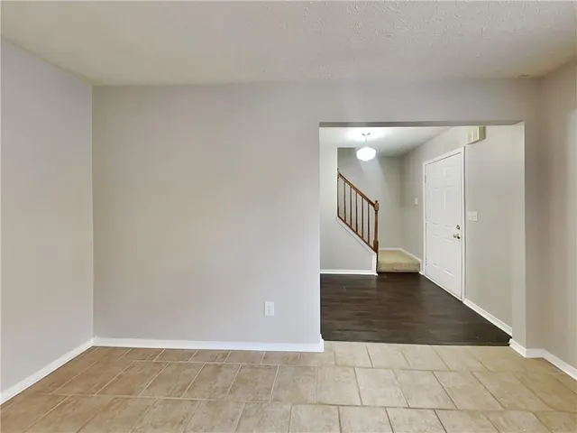 an empty room with wooden floor and staircase