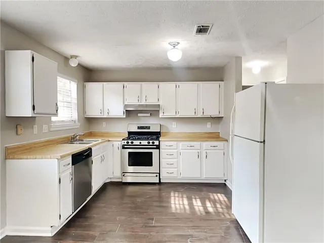 a kitchen with white cabinets and white appliances