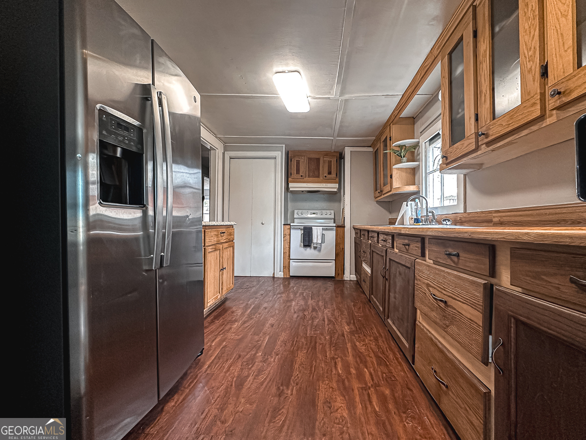 3305 Cherokee Avenue Columbus, GA 31906 - Photo 12 of 49 a kitchen with stainless steel appliances granite countertop a refrigerator a sink and wooden cabinets