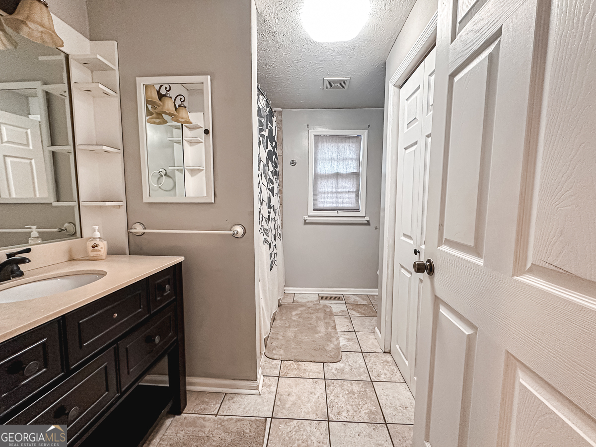 3305 Cherokee Avenue Columbus, GA 31906 - Photo 29 of 49 a spacious bathroom with a granite countertop sink a mirror and a