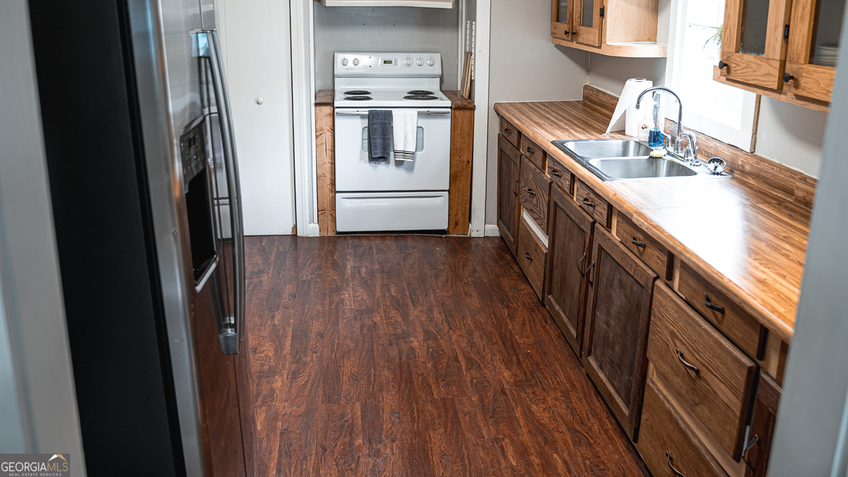 3305 Cherokee Avenue Columbus, GA 31906 - Photo 7 of 49 a kitchen with stainless steel appliances granite countertop a refrigerator a sink and wooden floors