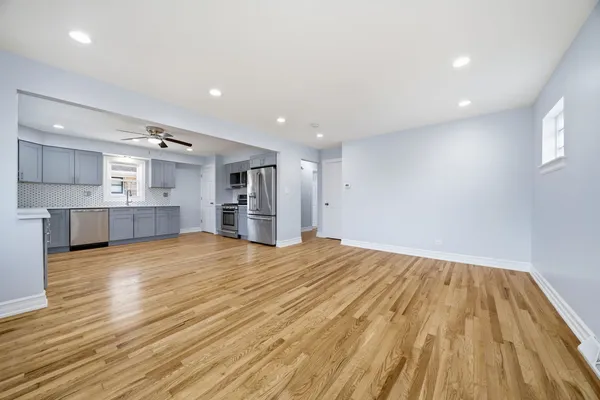 a kitchen with cabinets stainless steel appliances and wooden floor
