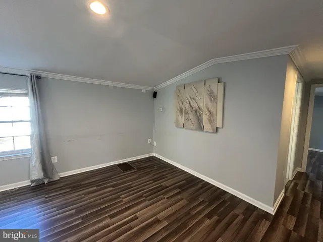 a view of a room with wooden floor and window