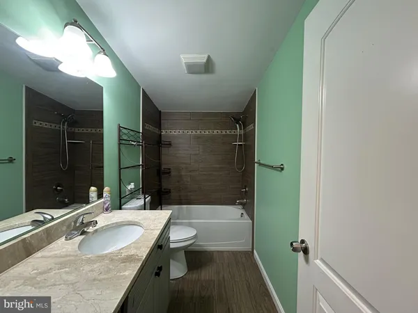 a bathroom with a sink a toilet a mirror and shower