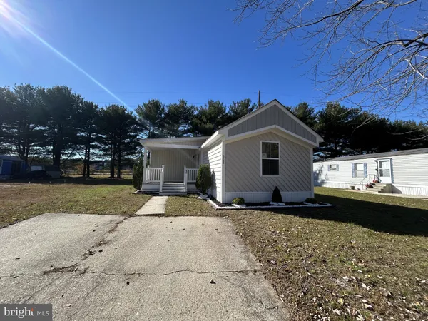 a view of a house with a yard and large trees