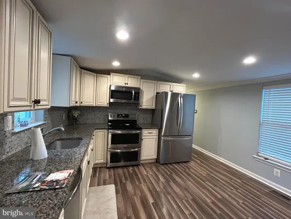 a kitchen with granite countertop a refrigerator and a stove top oven