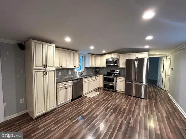 a kitchen with stainless steel appliances granite countertop a refrigerator and a stove top oven
