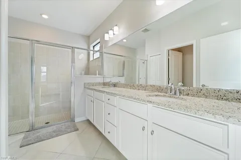 a bathroom with a granite countertop sink mirror and shower