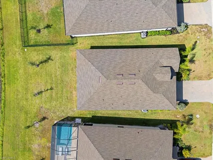 an aerial view of a residential houses with yard