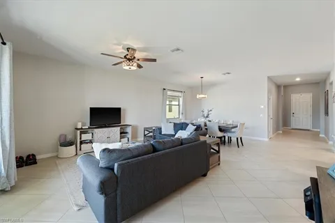 a living room with furniture a ceiling fan and a rug