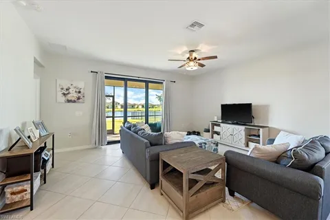 a living room with furniture a flat screen tv and a window