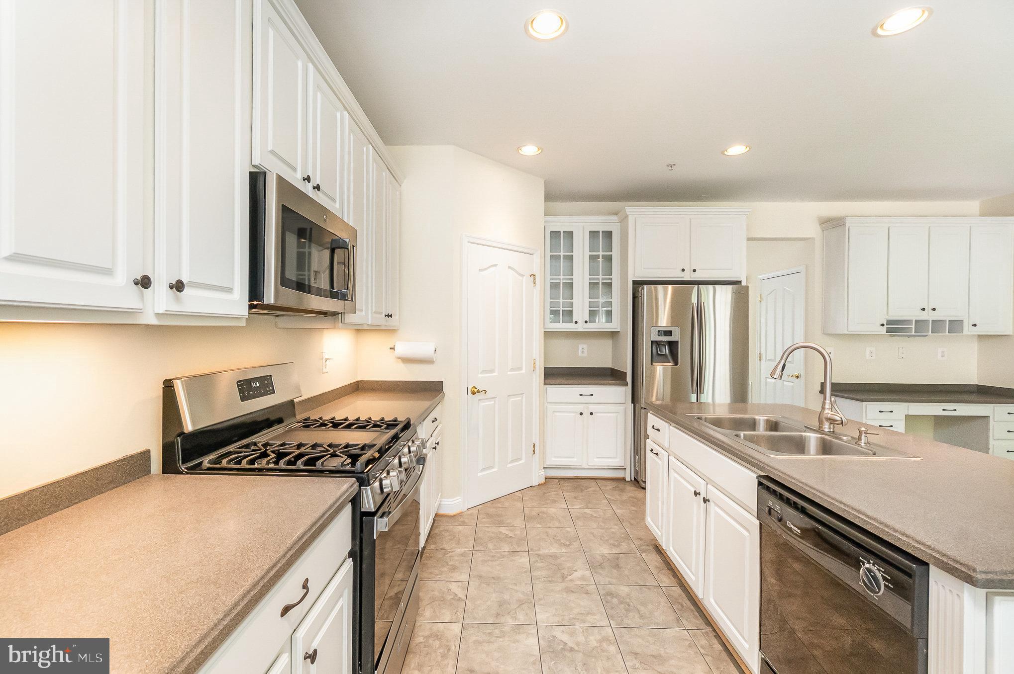 512 Callander Way Abingdon, MD 21009 - Photo 11 of 40 a kitchen with a sink a stove and cabinets