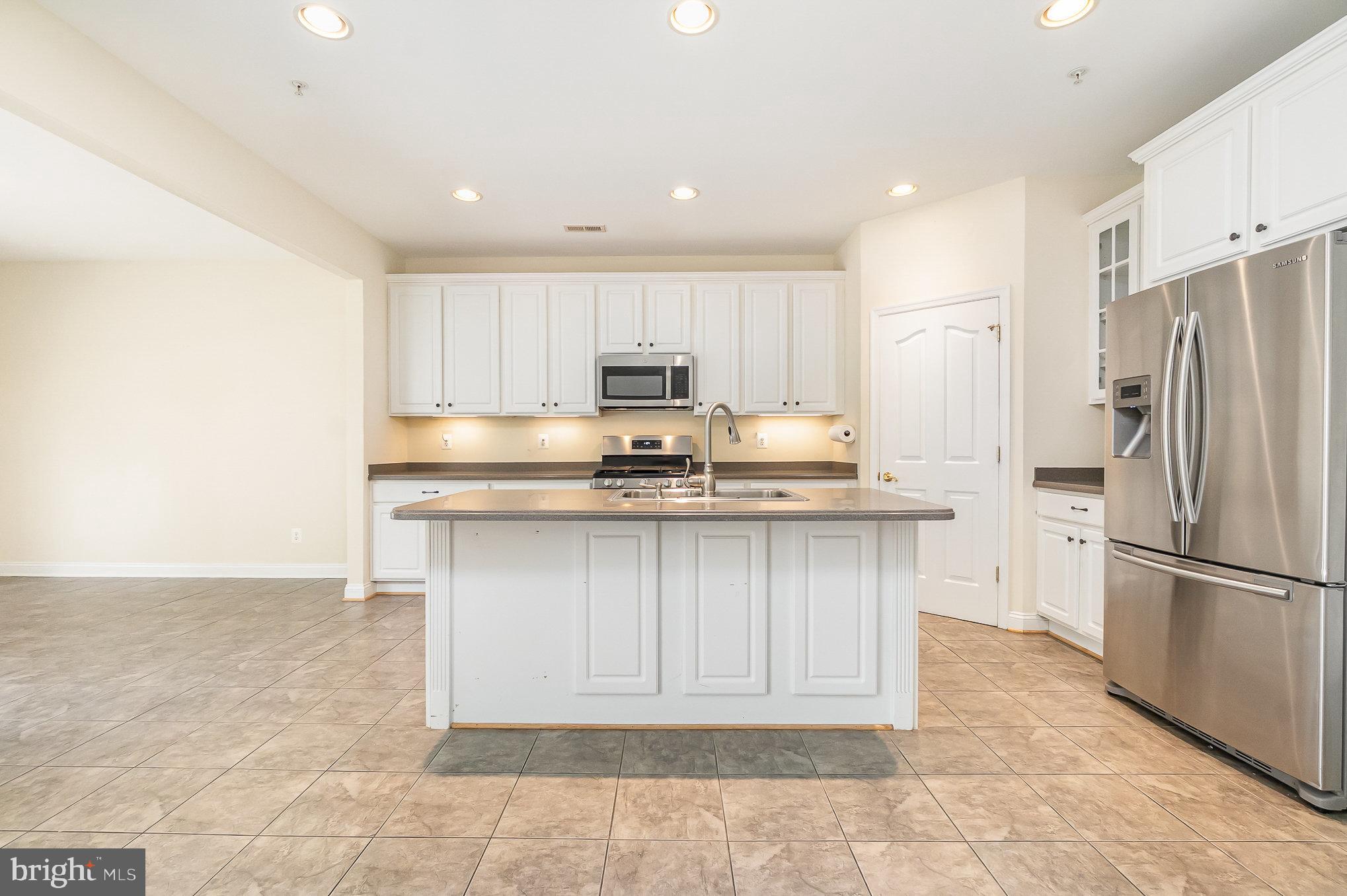 512 Callander Way Abingdon, MD 21009 - Photo 12 of 40 a kitchen with stainless steel appliances granite countertop a refrigerator sink and cabinets