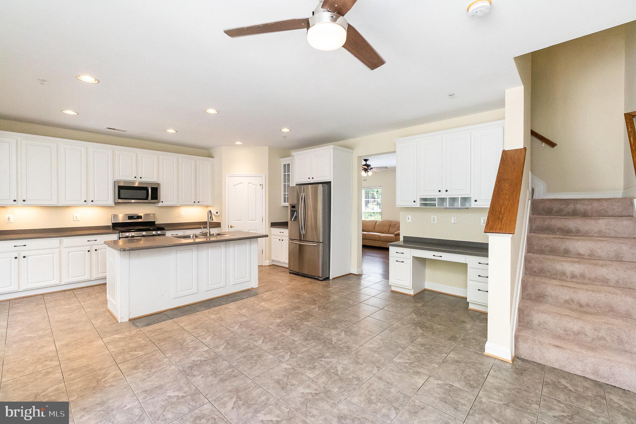 512 Callander Way Abingdon, MD 21009 - Photo 13 of 40 a kitchen with stainless steel appliances kitchen island granite countertop a refrigerator and a stove top oven
