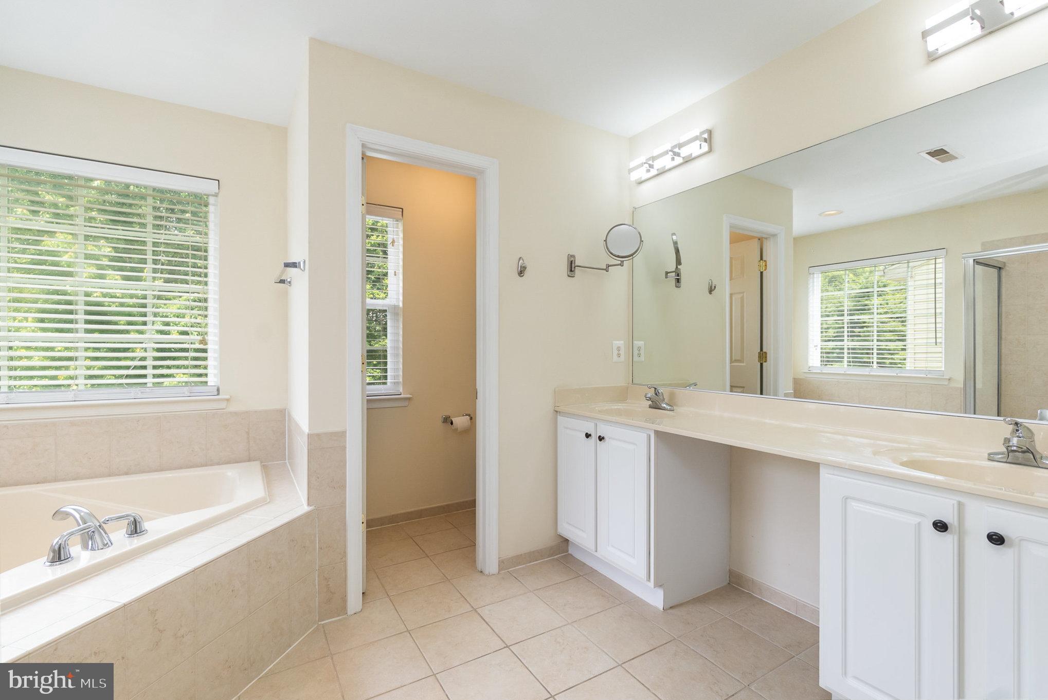 512 Callander Way Abingdon, MD 21009 - Photo 22 of 40 a spacious bathroom with a granite countertop tub sink shower and a mirror