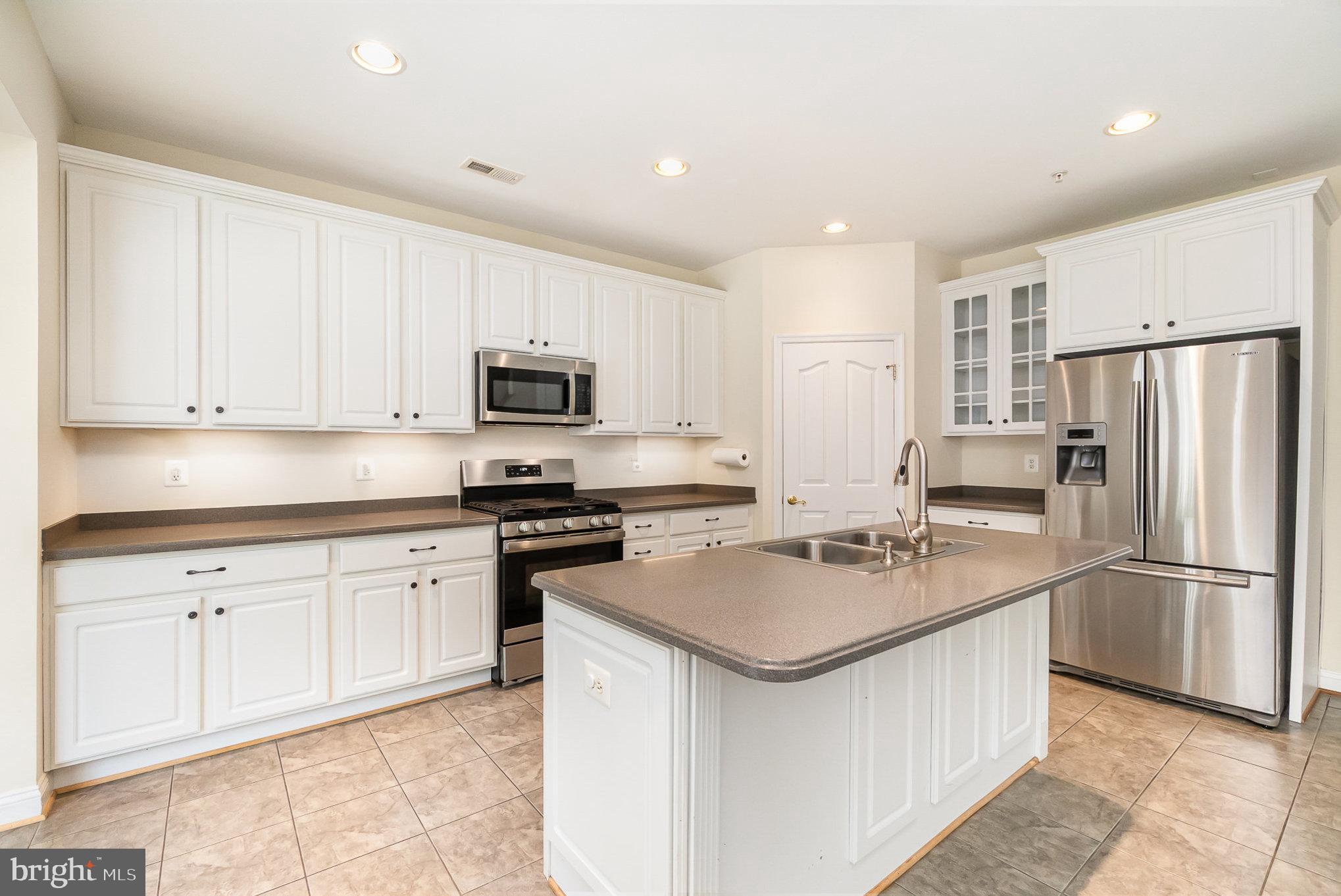 512 Callander Way Abingdon, MD 21009 - Photo 10 of 40 a kitchen with white cabinets and stainless steel appliances