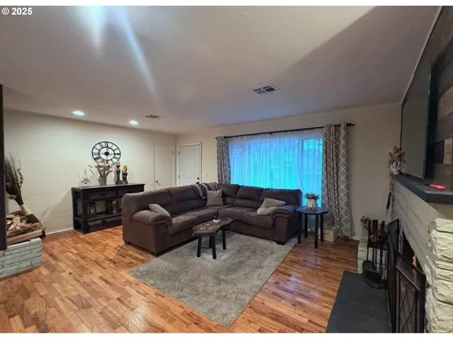 a living room with furniture a window and a flat screen tv