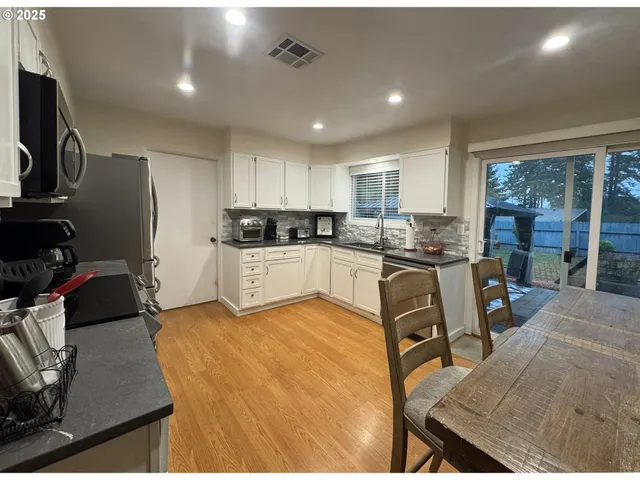a kitchen with a table chairs refrigerator and microwave
