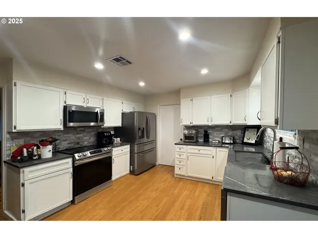 a kitchen with stainless steel appliances granite countertop a stove top oven a sink and dishwasher