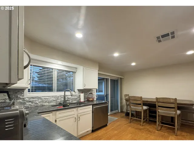 a kitchen with kitchen island granite countertop a sink counter and chairs