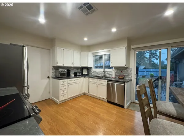 a kitchen with a refrigerator and wooden floor