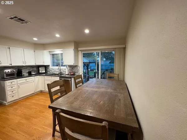 a kitchen with a table chairs sink and cabinets