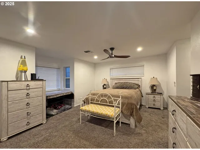 a spacious bedroom with a bed and a chandelier