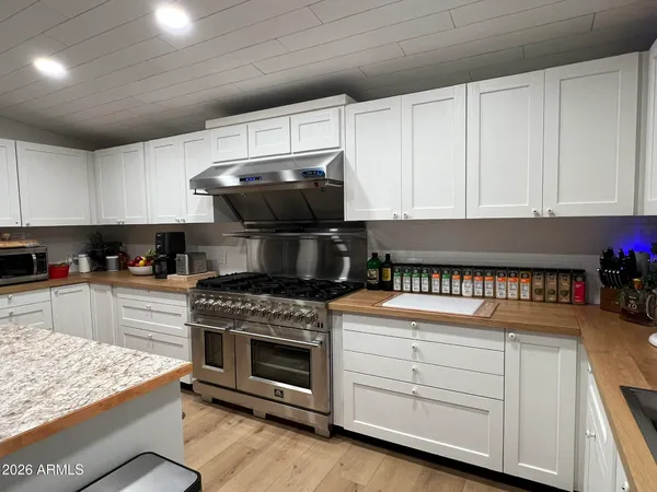 a kitchen with stainless steel appliances granite countertop a stove and a white cabinets