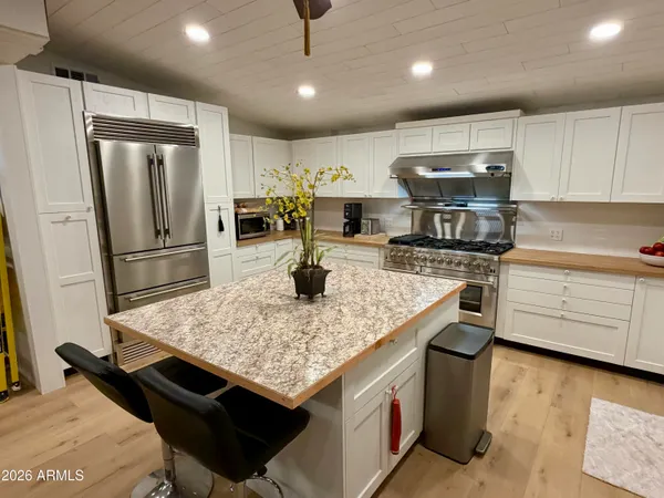 a kitchen with stainless steel appliances granite countertop a sink stove and refrigerator