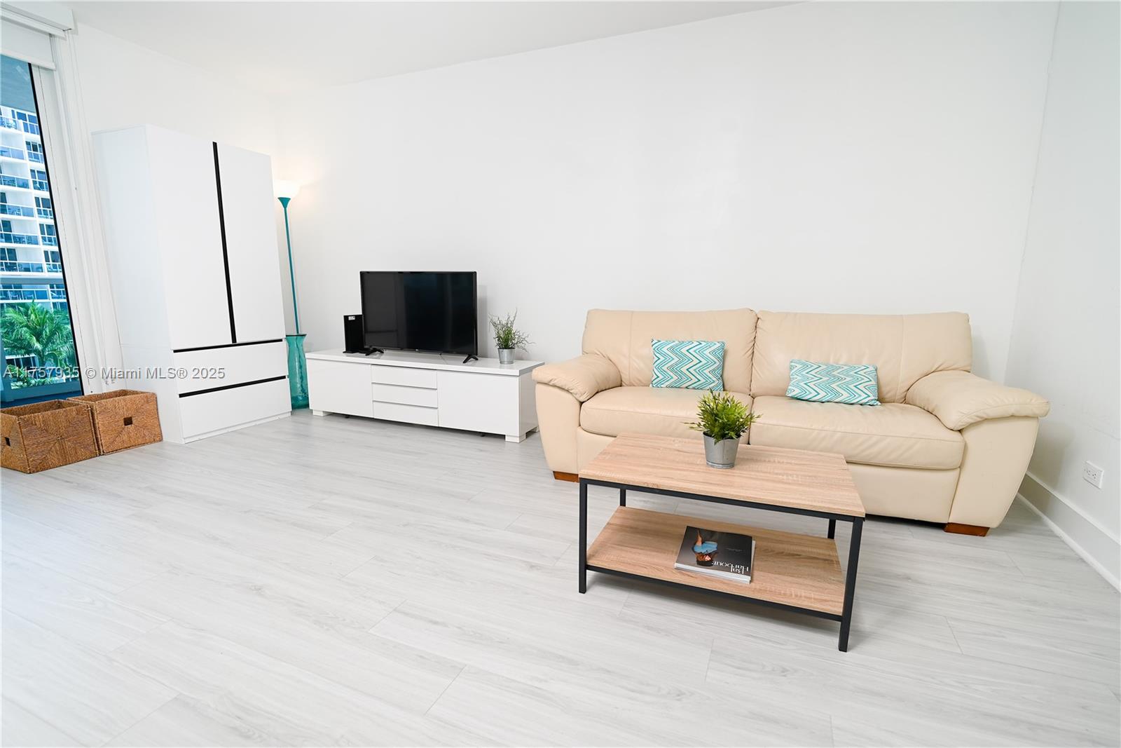 2301 Collins Avenue, Unit 921 Miami Beach, FL 33139 - Photo 11 of 45 a living room with furniture and a flat screen tv