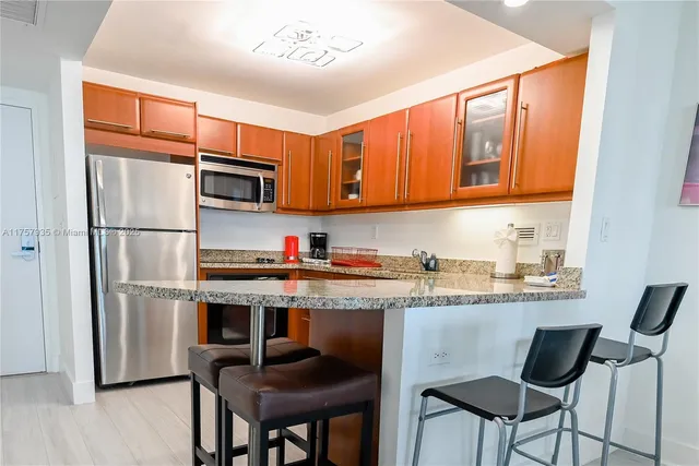a kitchen with stainless steel appliances granite countertop a refrigerator and a stove top oven