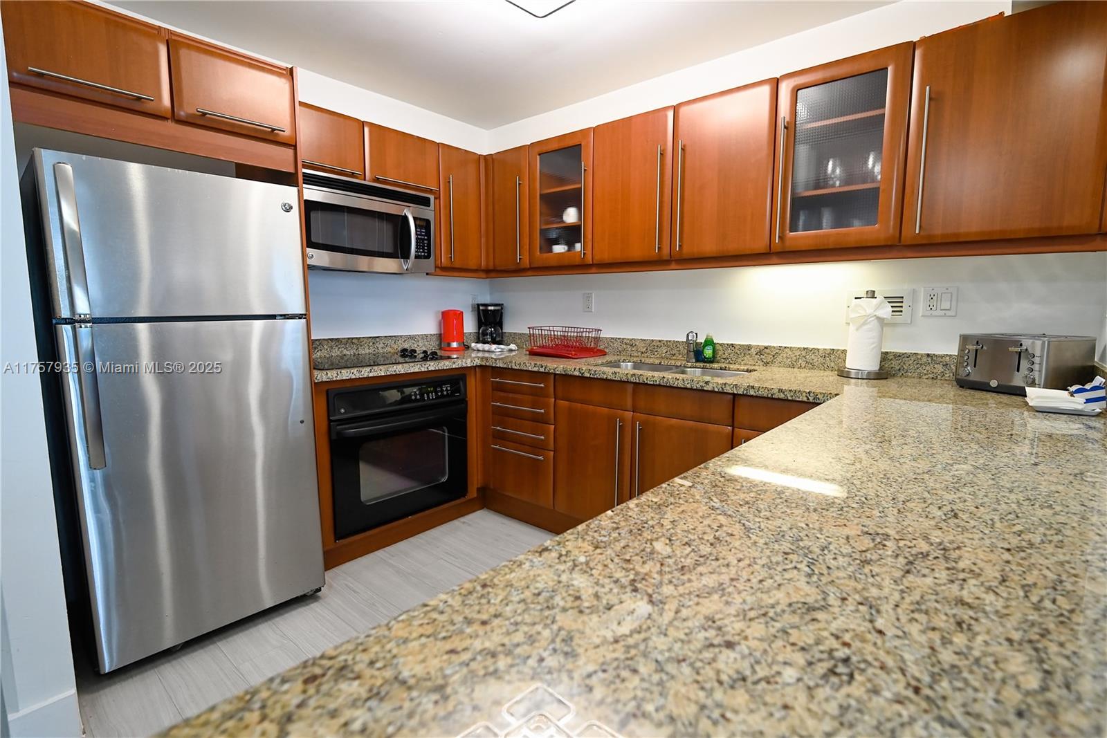 2301 Collins Avenue, Unit 921 Miami Beach, FL 33139 - Photo 15 of 45 a kitchen with stainless steel appliances granite countertop a stove a sink dishwasher a refrigerator and a microwave