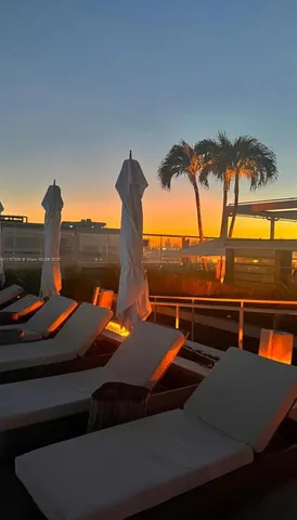 a patio with a table and chairs under an umbrella