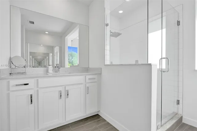 a bathroom with a double vanity sink mirror and shower