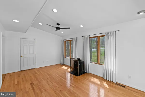 a view of empty room with floor to ceiling window and ceiling fan