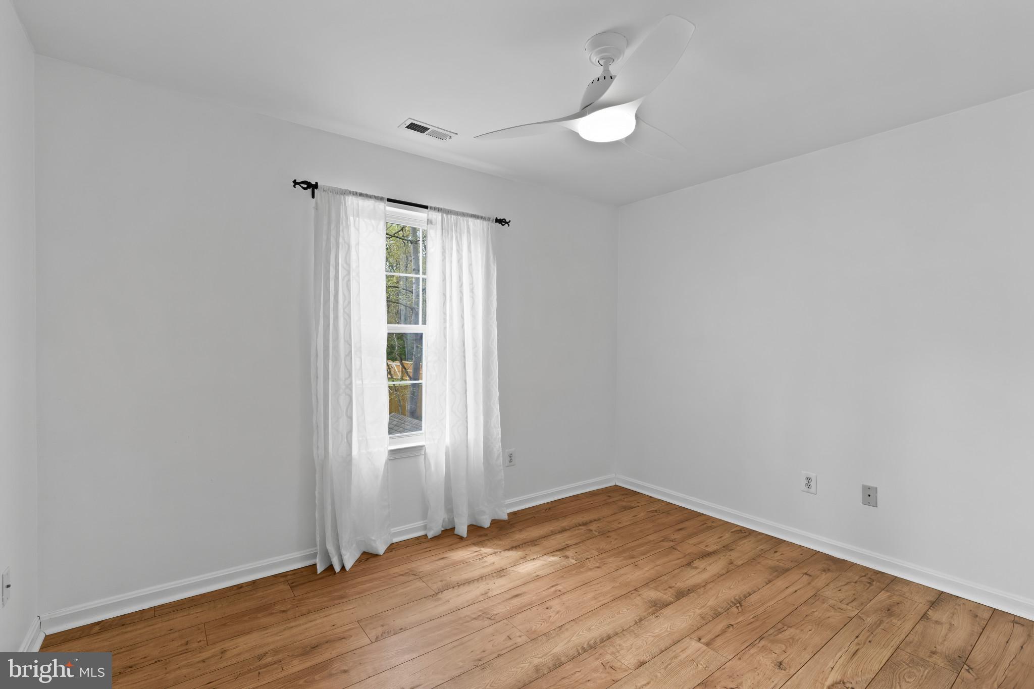 3530 Shady Drive Edgewater, MD 21037 - Photo 19 of 26 an empty room with wooden floor fan and window