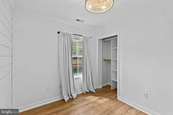 an empty room with wooden floor and a window