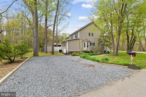 a view of a house with a yard and large tree